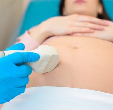 close-up shot of obstetrician gynecologist making of ultrasound examination pregnant woman